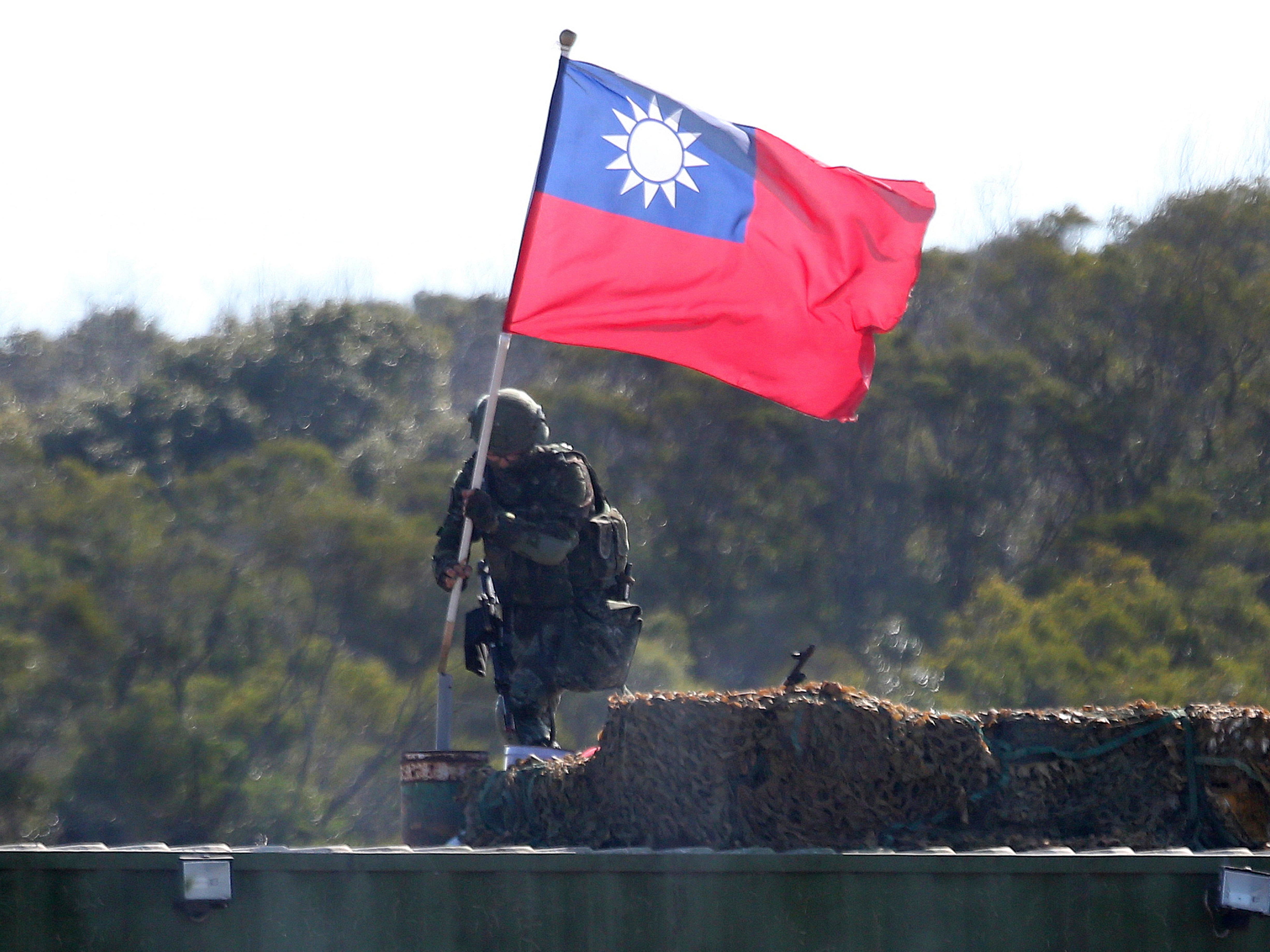 A soldier holds a Taiwanese flag during a military exercise aimed at repelling an attack from China