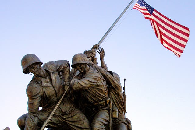 <p>The American flag flies over the US Marine Memorial in Arlington depicting the flag raising at Iwo Jima during the Second World War</p>