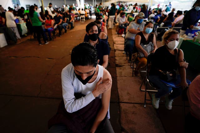 <p>A youth keeps his hand on the spot where he was vaccinated with Russia's Sputnik V coronavirus vaccine during a vaccination drive at University Stadium in Mexico City</p>