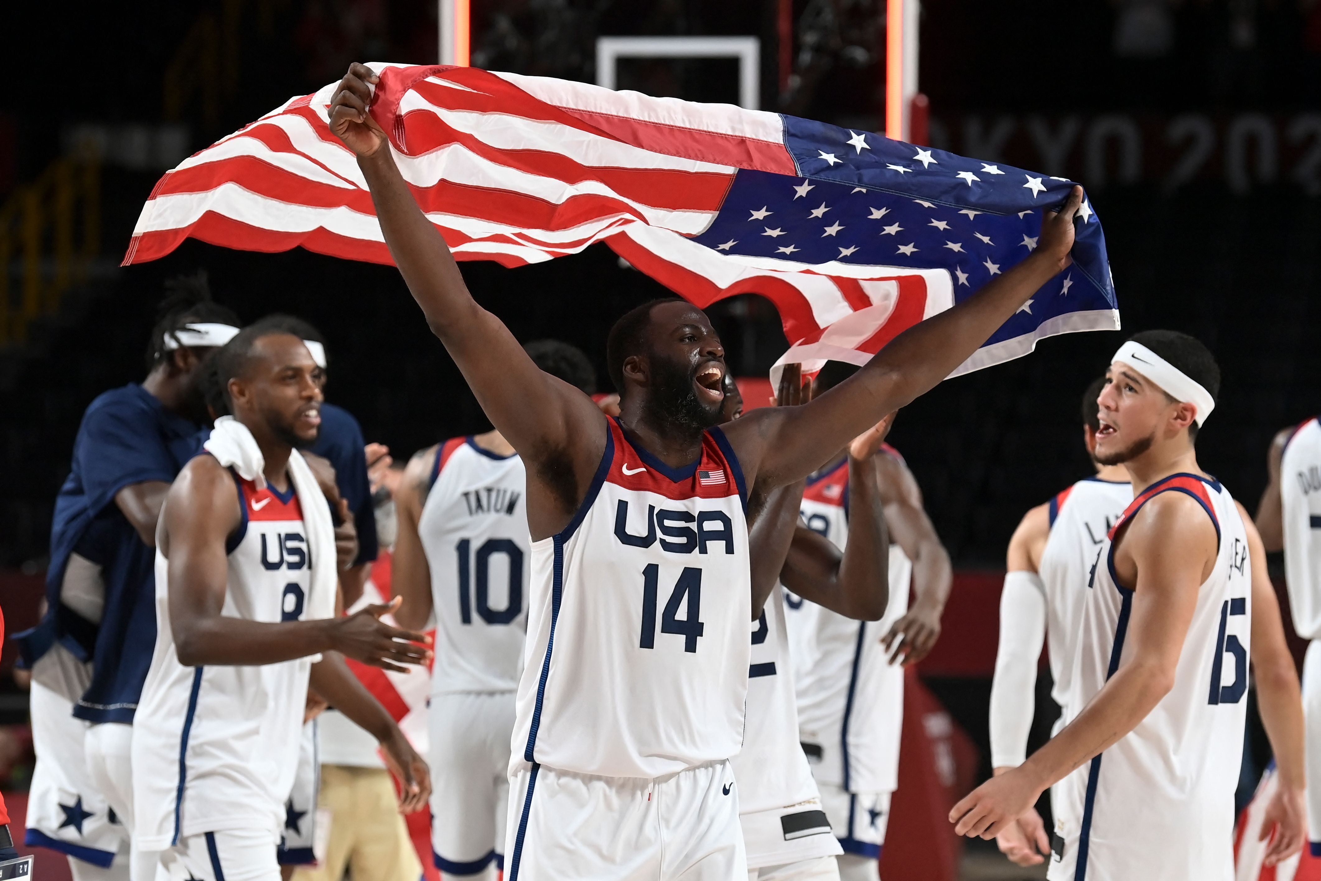 USA's Draymond Green celebrates with the flag of the USA