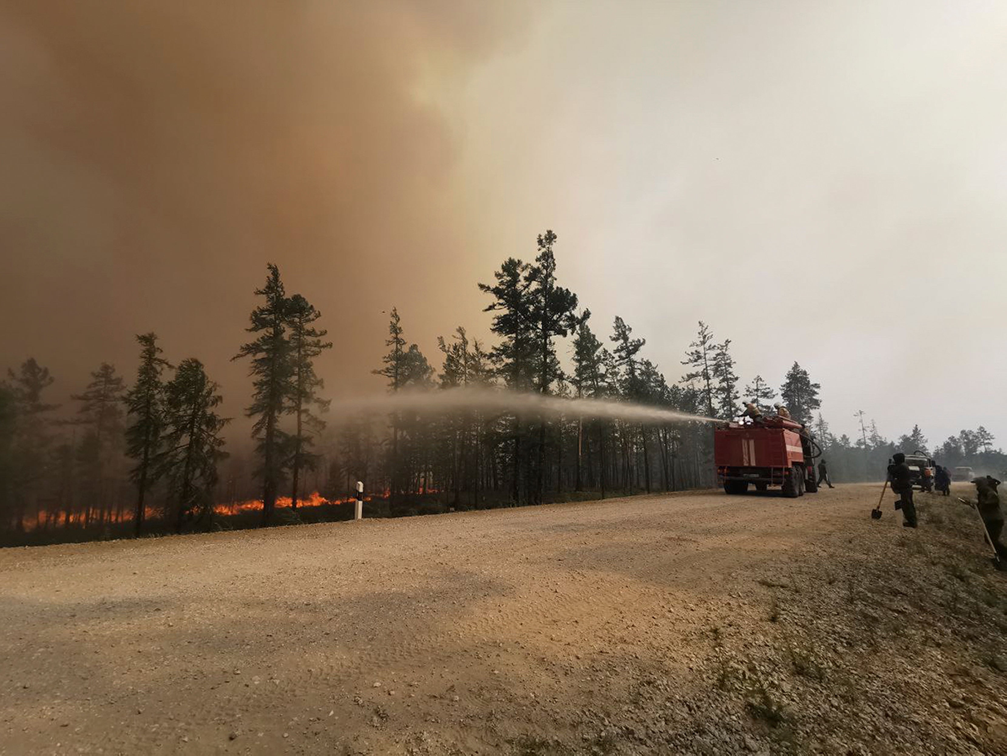 Firefighters work at the scene of a forest fire in the Gorny Ulus area west of Yakutsk today