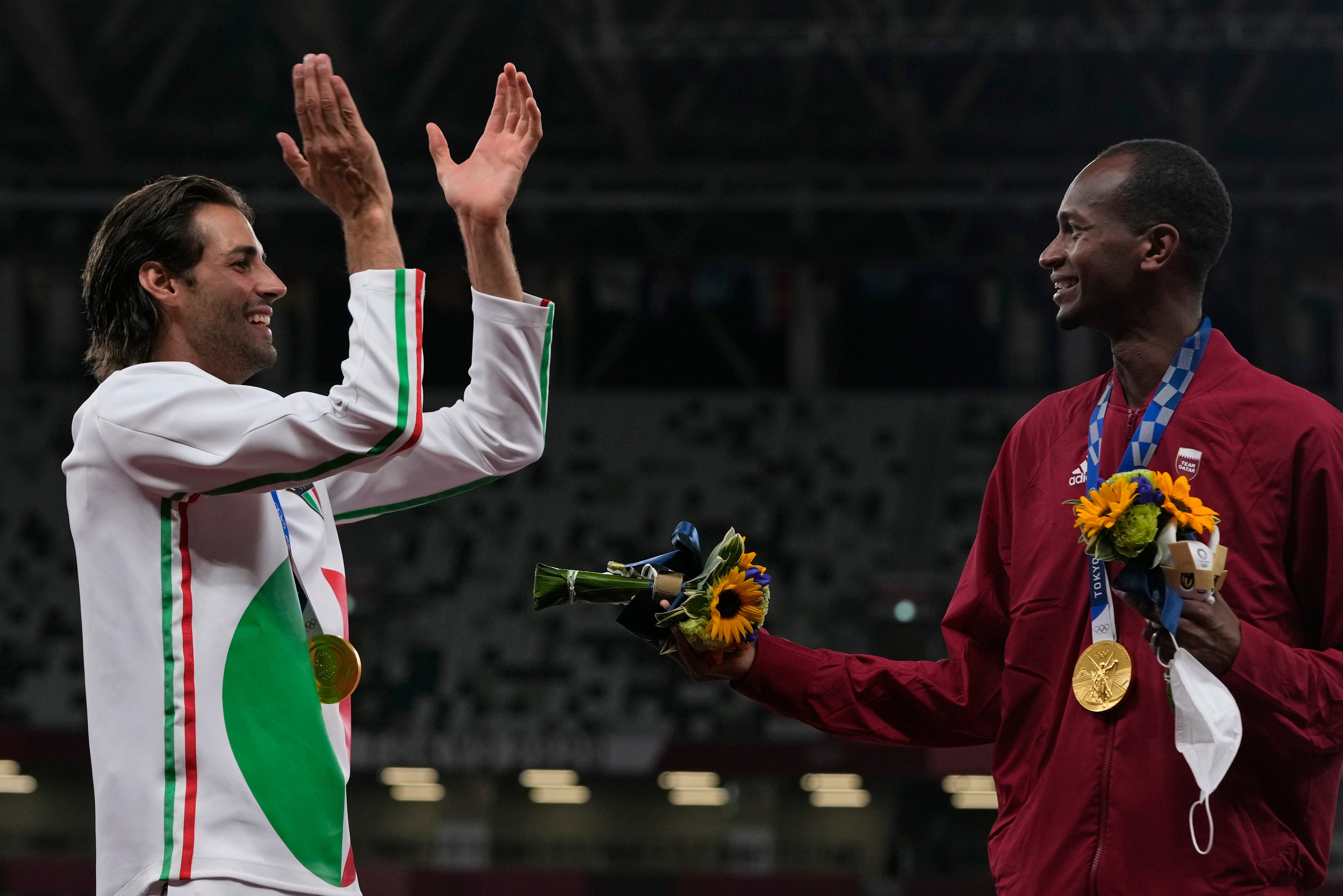 Joint gold medalists Mutaz Barshim (right) of Qatar and Gianmarco Tamberi off Italy celebrate on the podium following the men’s high jump final (Francisco Seco/AP)