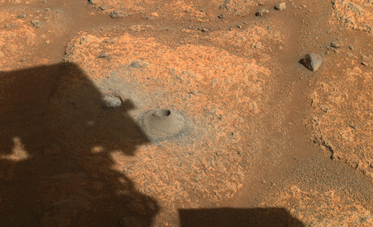 This image taken by one the hazard cameras aboard NASA’s Perseverance rover on Aug. 6, 2021, shows the hole drilled in what the rover’s science team calls a “paver rock” in preparation for the mission’s first attempt to collect a sample from Mars