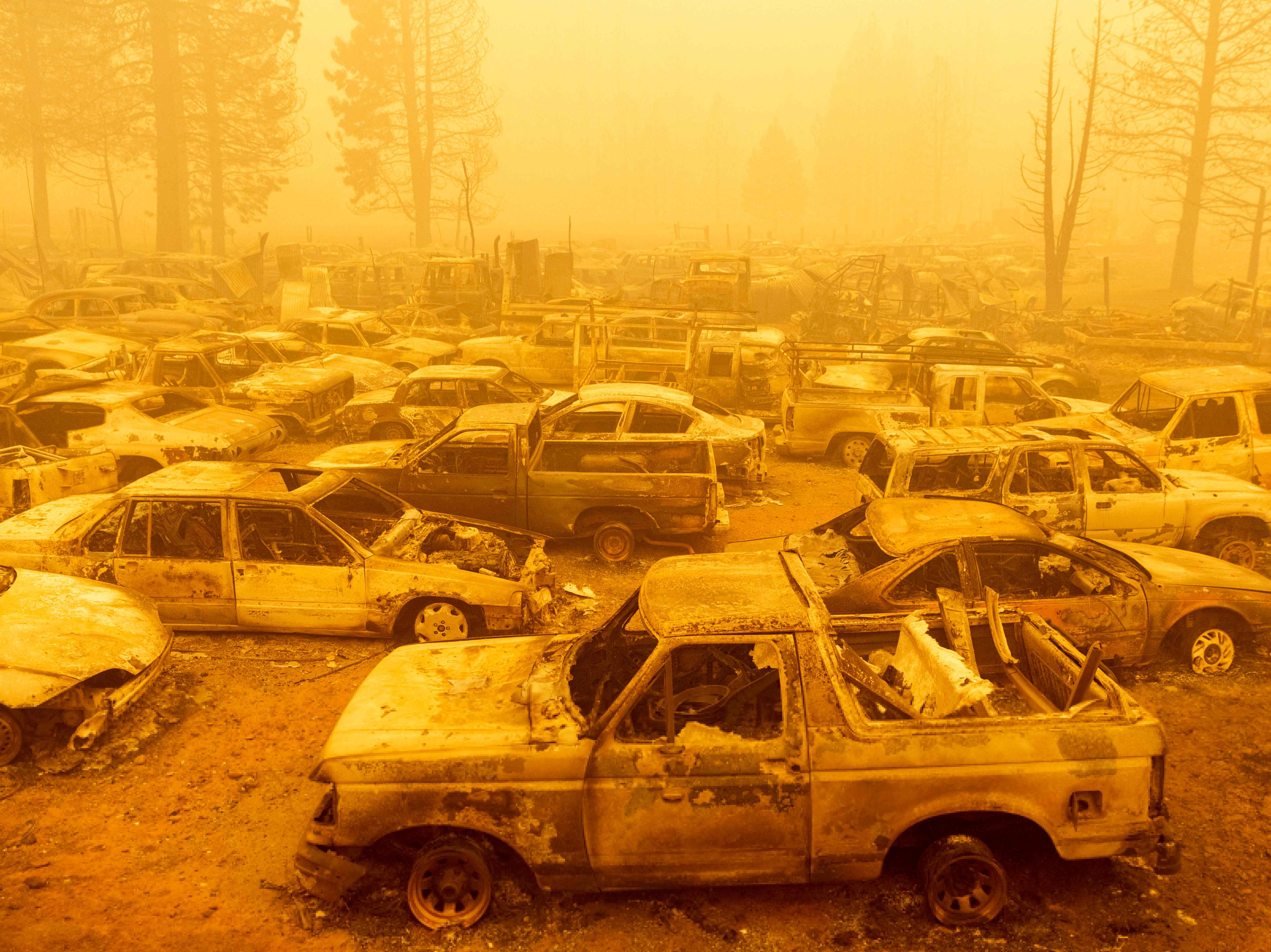 Dozens of burned vehicles rest in heavy smoke during the Dixie fire in Greenville, California on 6 August 2021