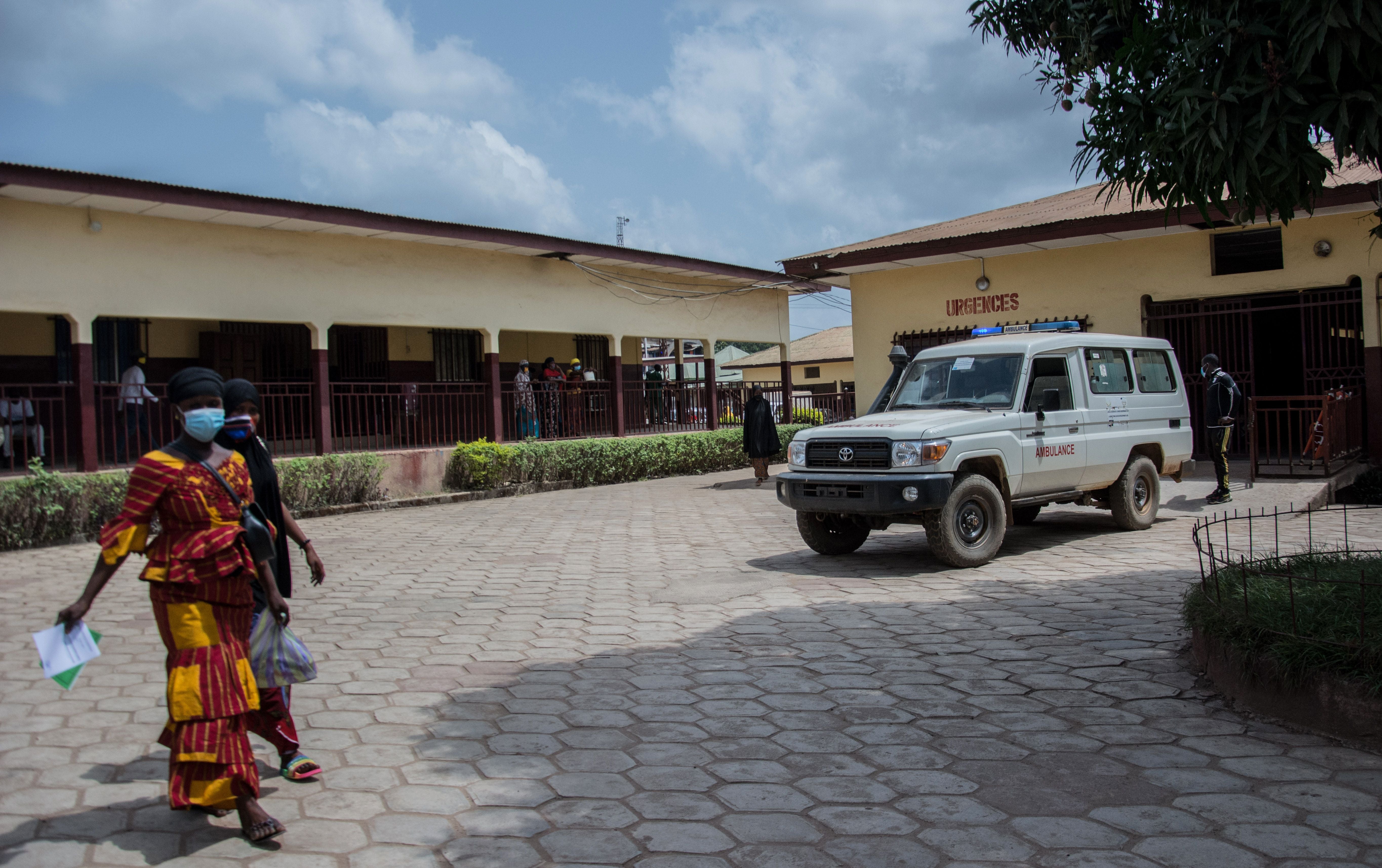 Two women walk through the emergency drop-off area at the N’zerekore Hospital where the first cases of Ebola were found at the end of January 2021