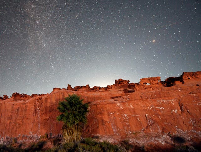 <p>A Perseid meteor (R) streaks across the sky over the planet Mars above the red sandstone area known as Little Finland, about 110 miles northeast of Las Vegas, early on August 12, 2020 in Gold Butte National Monument, Nevada.</p>