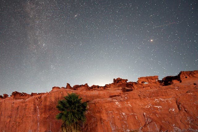 <p>A Perseid meteor (R) streaks across the sky over the planet Mars above the red sandstone area known as Little Finland, about 110 miles northeast of Las Vegas, early on August 12, 2020 in Gold Butte National Monument, Nevada.</p>