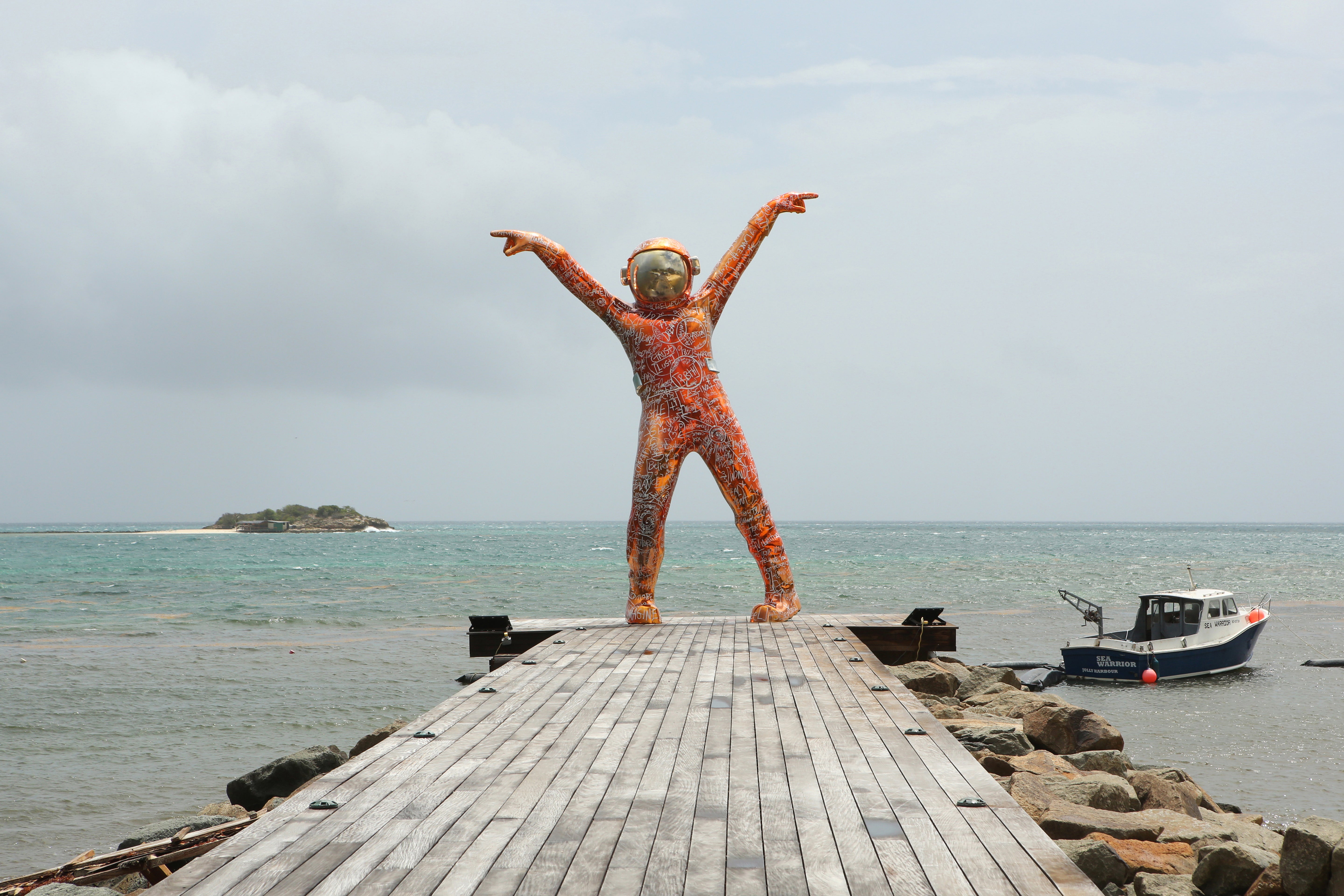 Antigua’s new 22ft, 3,000 pound sculpture Boonji Spaceman, standing at the end of a small pier at Hodges Bay resort on Antigua’s north coast. The piece was designed by Malibu-based artist Brendan Murphy, with its aim to lift the human spirit highlighting the artist’s fascination with space. Picture date: Saturday, July 24, 2021. Photographer: Johnny Green/PA