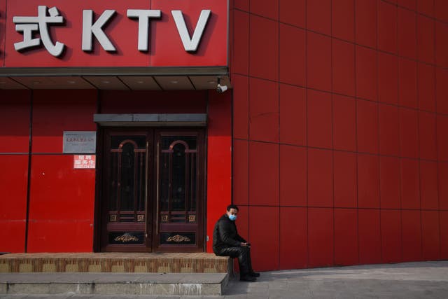 <p>FILE. A man wears a face mask outside a closed karaoke lounge in Beijing on 25 February, 2020. - China has said that it will ban karaoke songs with ‘illegal’ content</p>