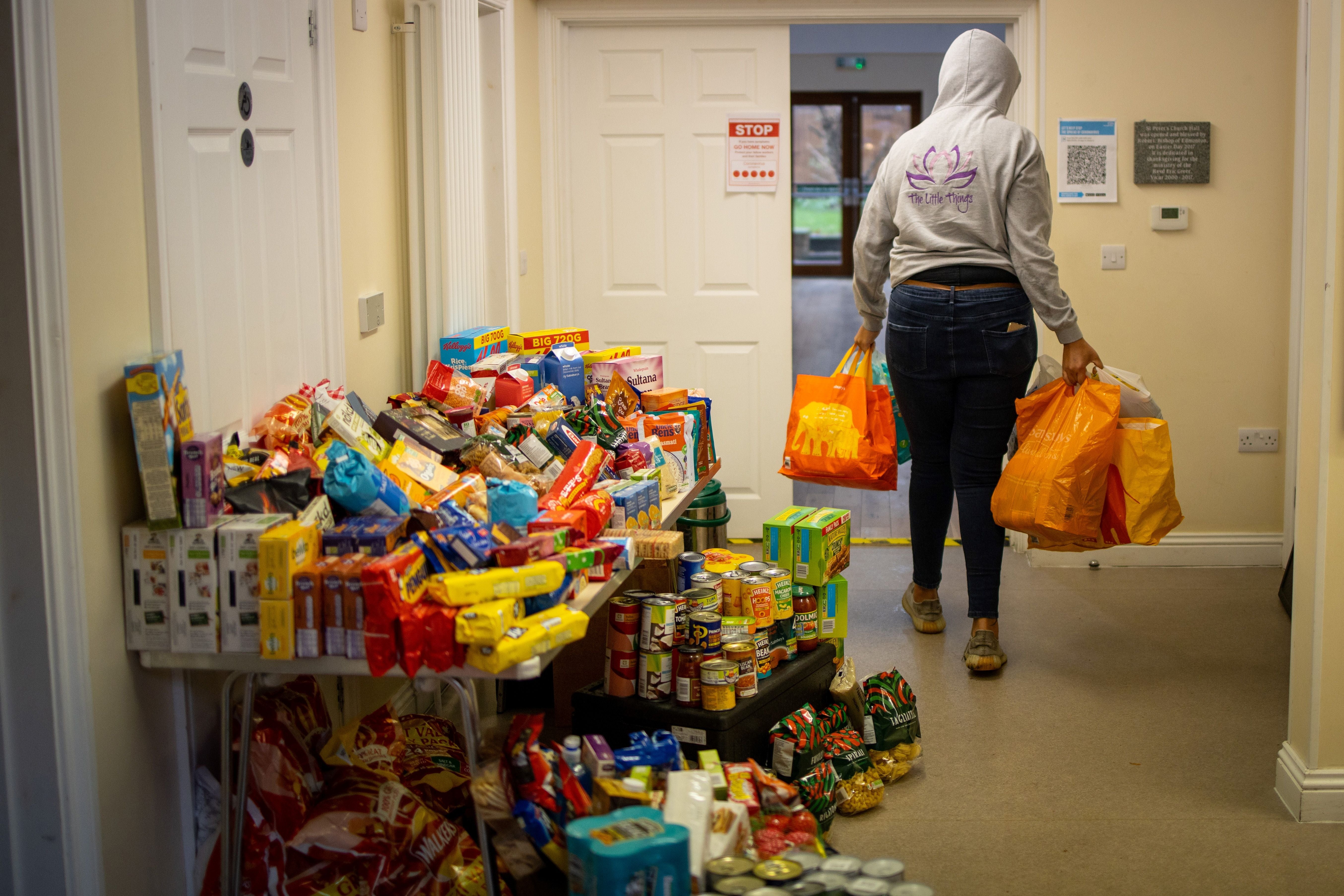A volunteer delivers donations to the Cooking Champions food bank in Grange Park, north London