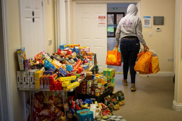 <p>A volunteer delivers donations to the Cooking Champions food bank in Grange Park, north London</p>
