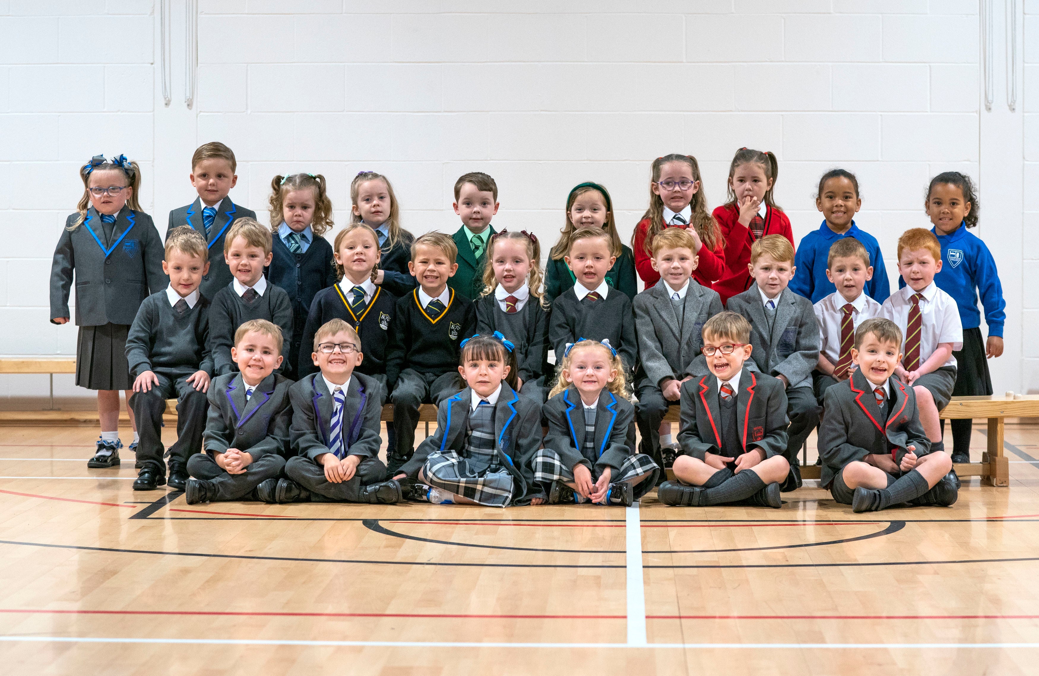 The 13 sets of twin are pictured in their new uniforms ahead of their first day at school