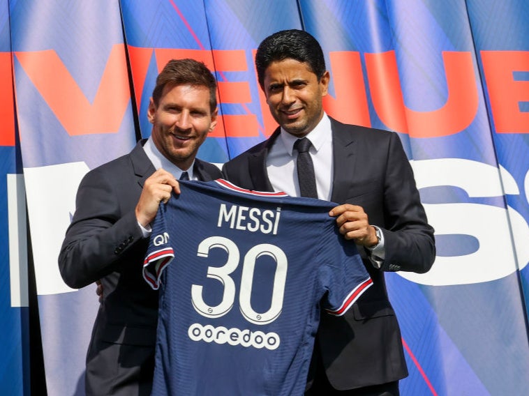 Lionel Messi poses with his jersey next to PSG president Nasser Al Khelaifi after Wednesday’s press conference at Parc des Princes