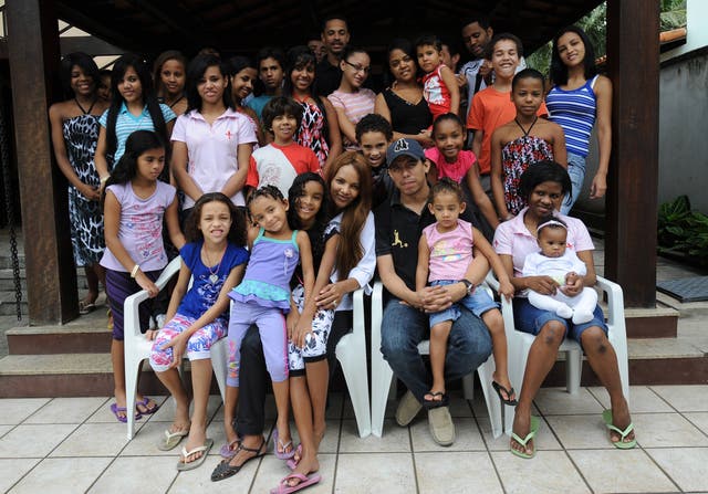 <p>FILE. Brazilian Flordelis dos Santos (C) poses with some of her 50 sons --four of them her own and another 46 adopted-- at their home in Niteroi, on the other side of the Bay of Rio de Janeiro, Brazil, 21 October, 2009. - She has been expelled from Brazil congress over her alleged role in her husband’s murder.</p>