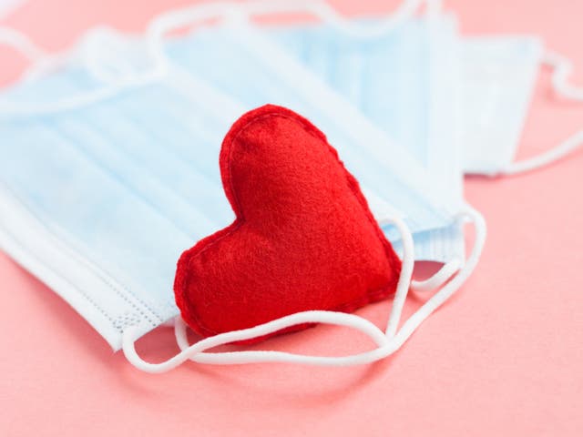 <p>Blue medical face masks and a red heart on a pink background</p>