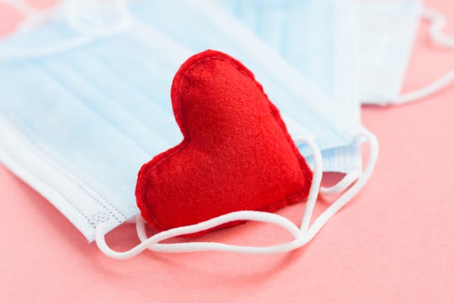<p>Blue medical face masks and a red heart on a pink background</p>