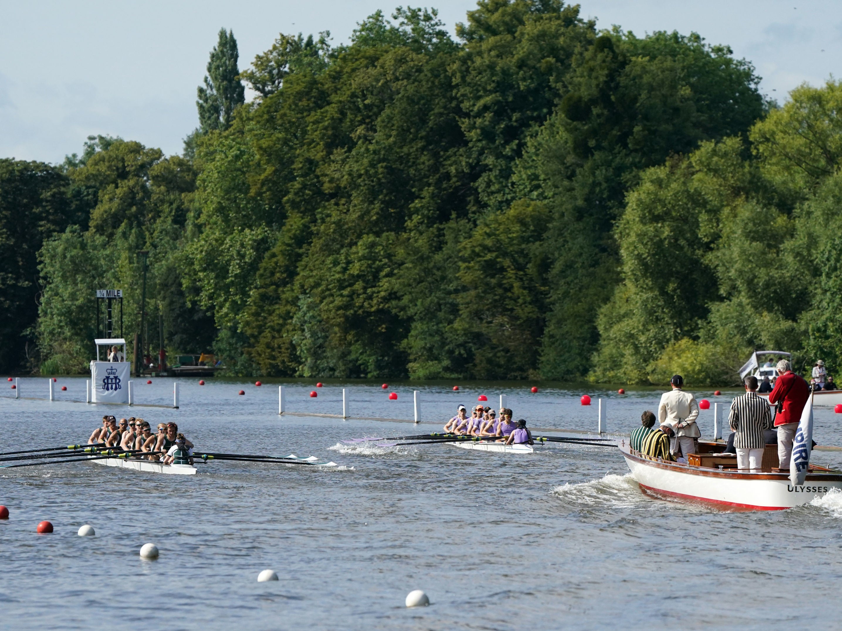Two rowing crews compete on the opening day of the 2021 Henley Royal Regatta alongside the river Thames