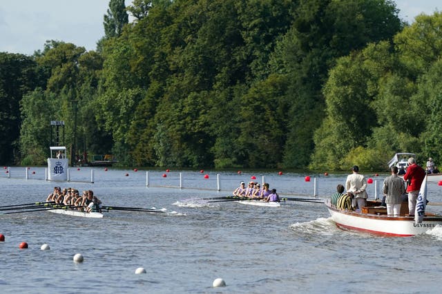 <p>Two rowing crews compete on the opening day of the 2021 Henley Royal Regatta alongside the river Thames</p>