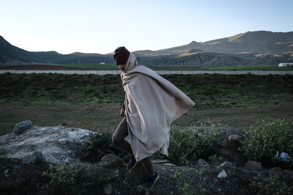 A young Afghan man walks next to a railway as they come from Van city after crossing the Iran-Turkey border