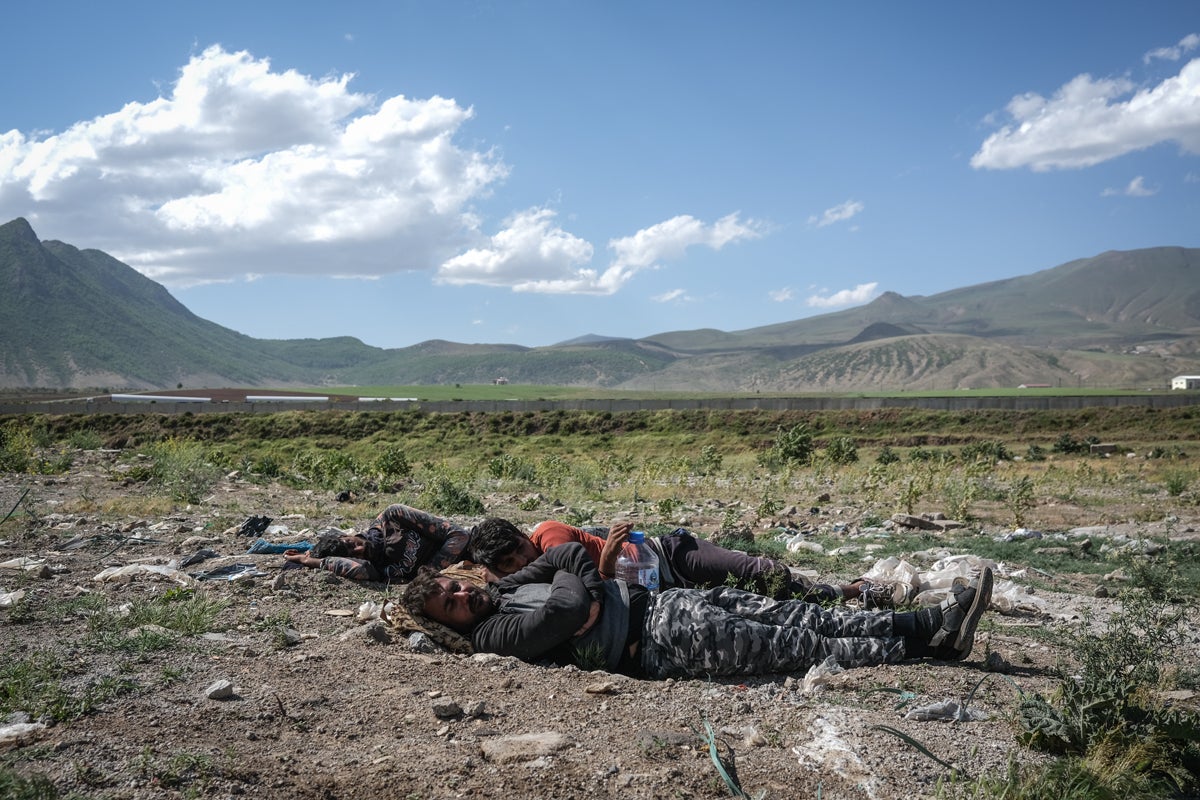 Two Afghans sleep in the open next to a highway near Tatvan district in Bitlis city