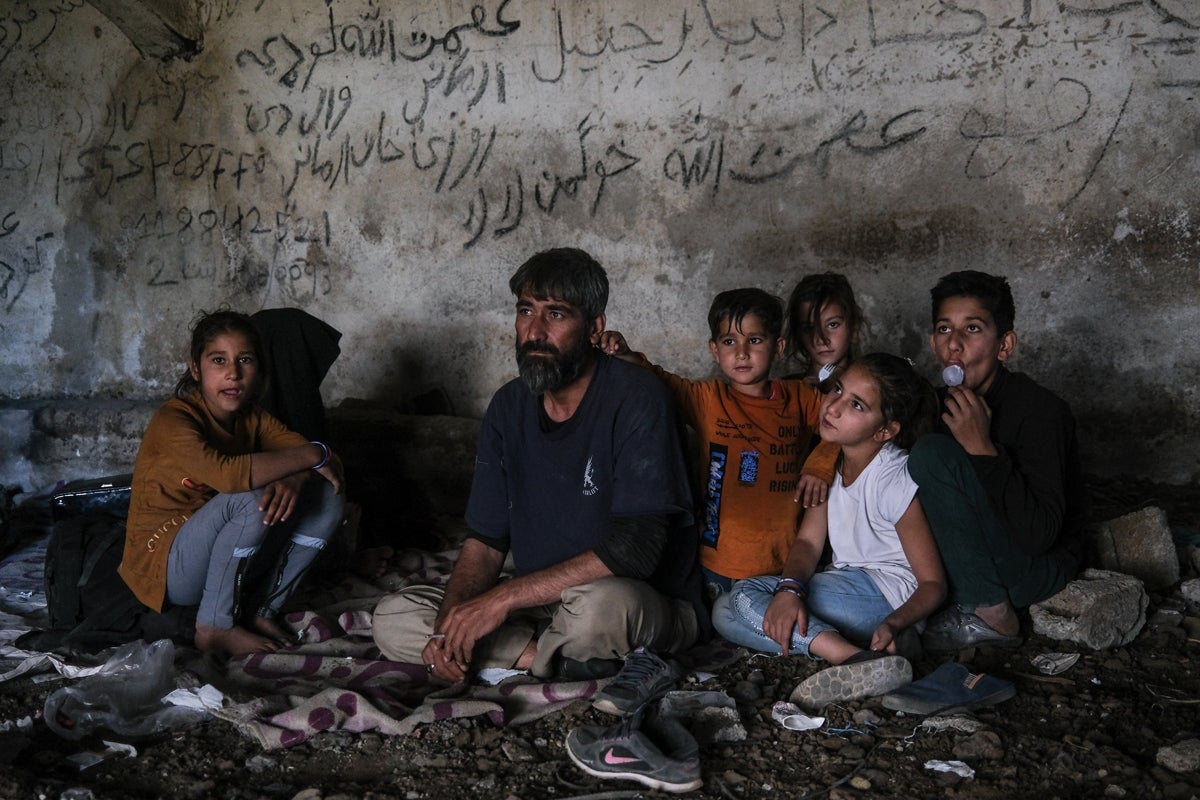 An Afghan family rests in an abandoned shepherd’s house