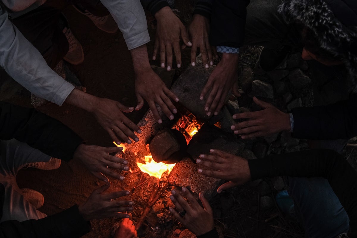 People sit round a bonfire as temperatures start to drop