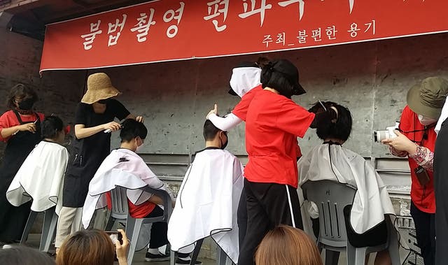 Mujeres surcoreanas a las que les afeitan la cabeza durante una protesta contra la pornografía de cámaras espía filmada en secreto en Seúl
