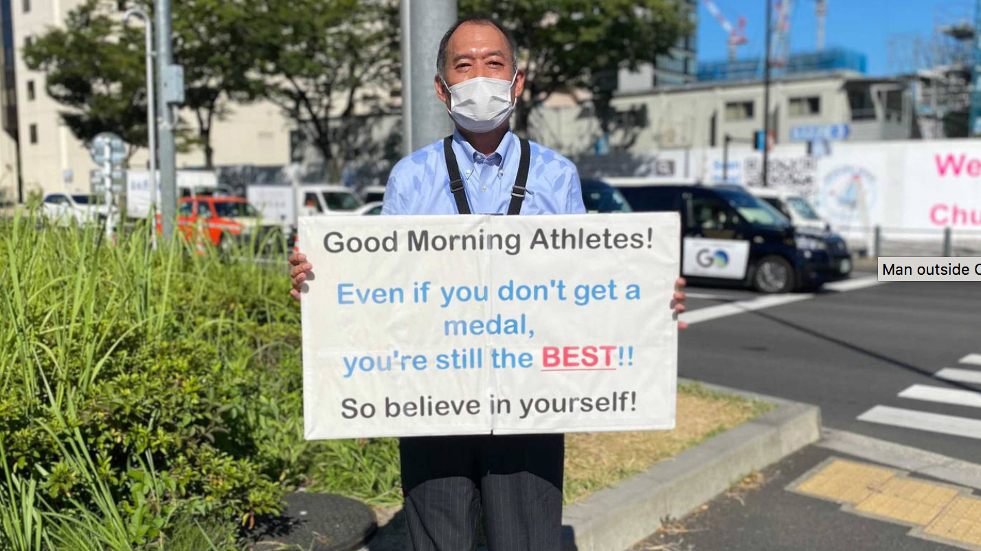 A mystery man held up motivational signs for the Olympic athletes