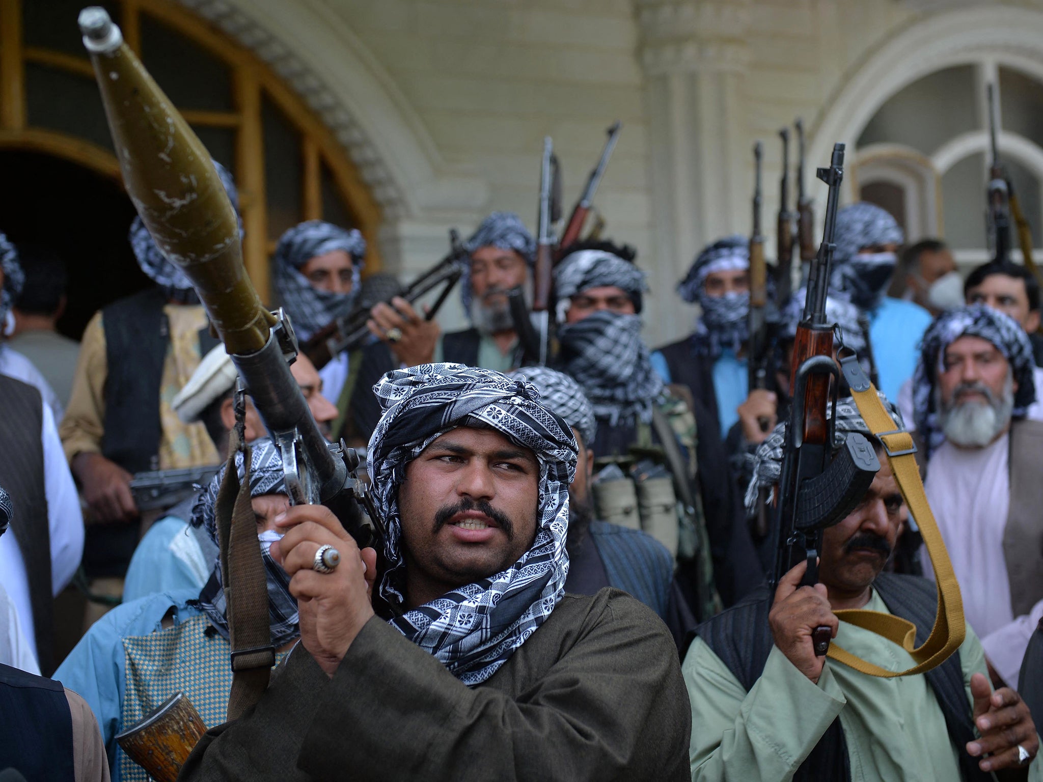 Militia gather with their weapons to support security forces against the Taliban