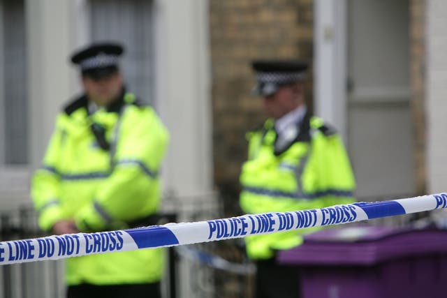 <p>Police officers stand outside a house in Hatherley Street, Liverpool after a raid searching for terror suspects in July 2007</p>