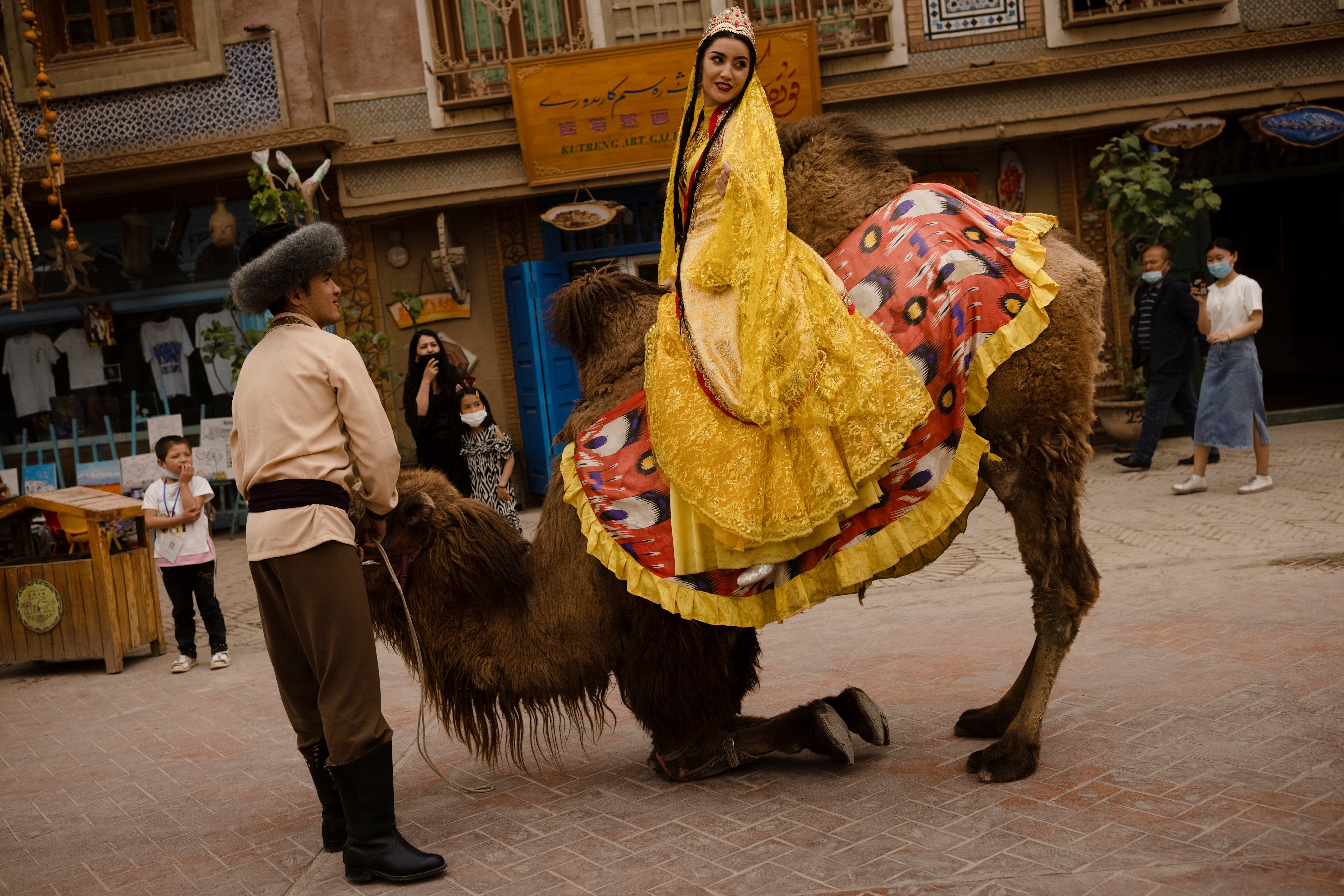 Traditional Uyghur costume is worn in a show for tourists with a camel procession in the old city in Kashgar