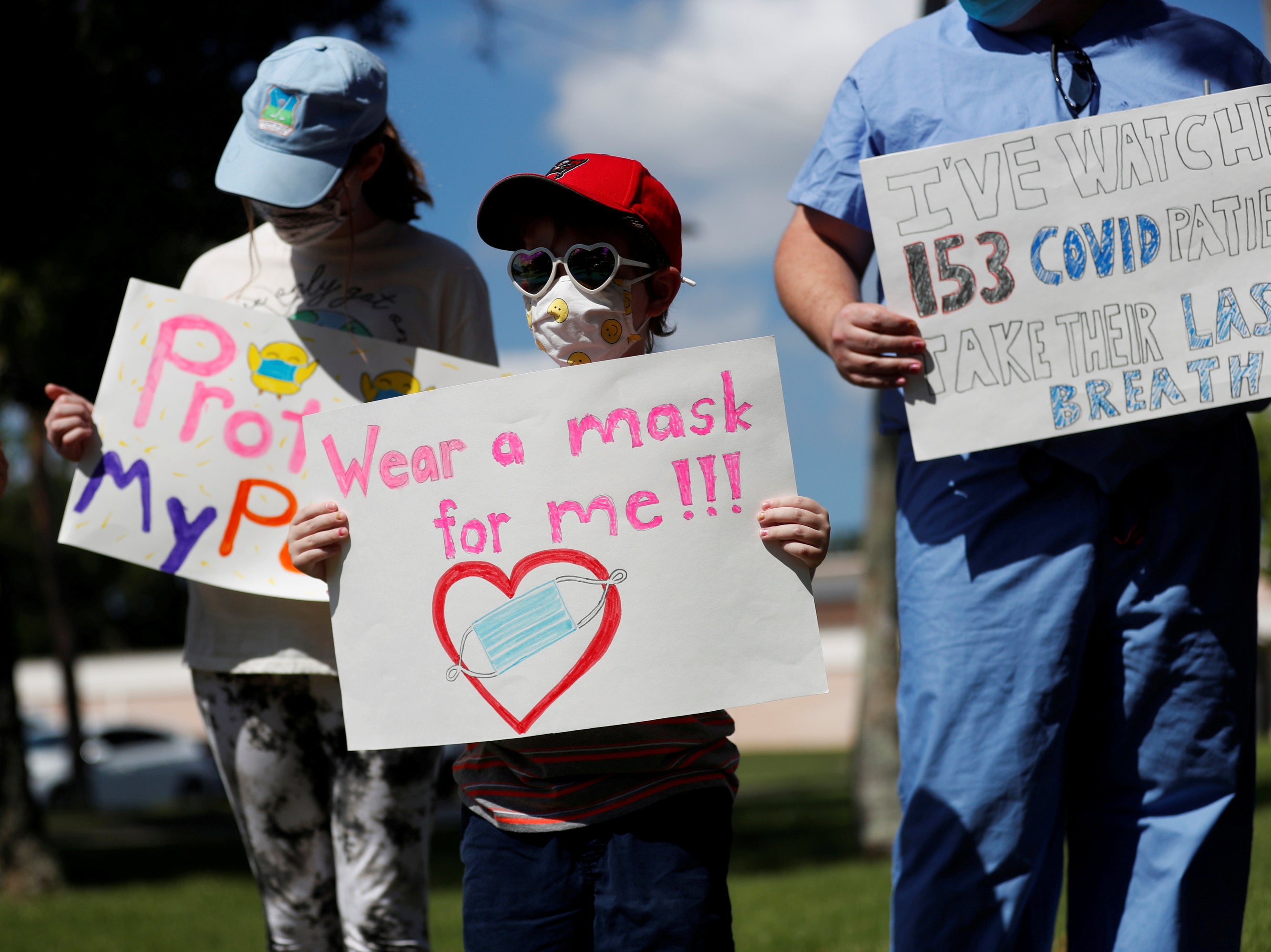 <p>Supporters of wearing masks in schools Sofia Deyo 11, and her brother Matthew Deyo 6, protest outside the Pinellas County Schools Administration Building in Largo, Florida, US, 9 August 2021</p>