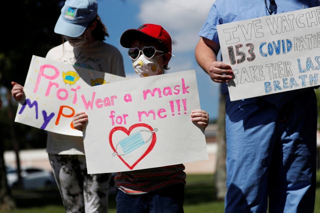 <p>Supporters of wearing masks in schools Sofia Deyo 11, and her brother Matthew Deyo 6, protest outside the Pinellas County Schools Administration Building in Largo, Florida, US, 9 August 2021</p>