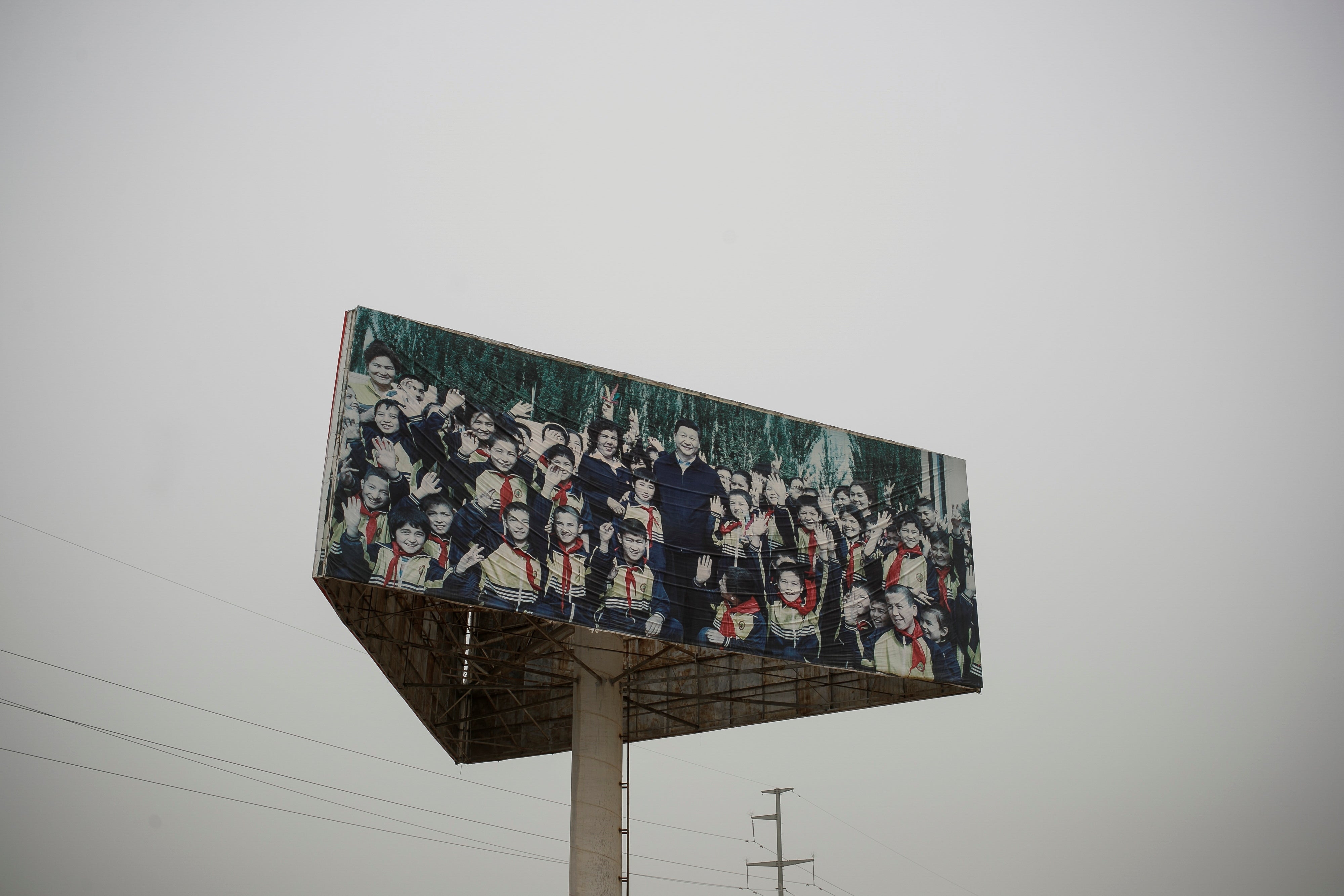 A poster on high in an industrial estate outside Kashgar prison showing the picture of President Xi with Uyghur children