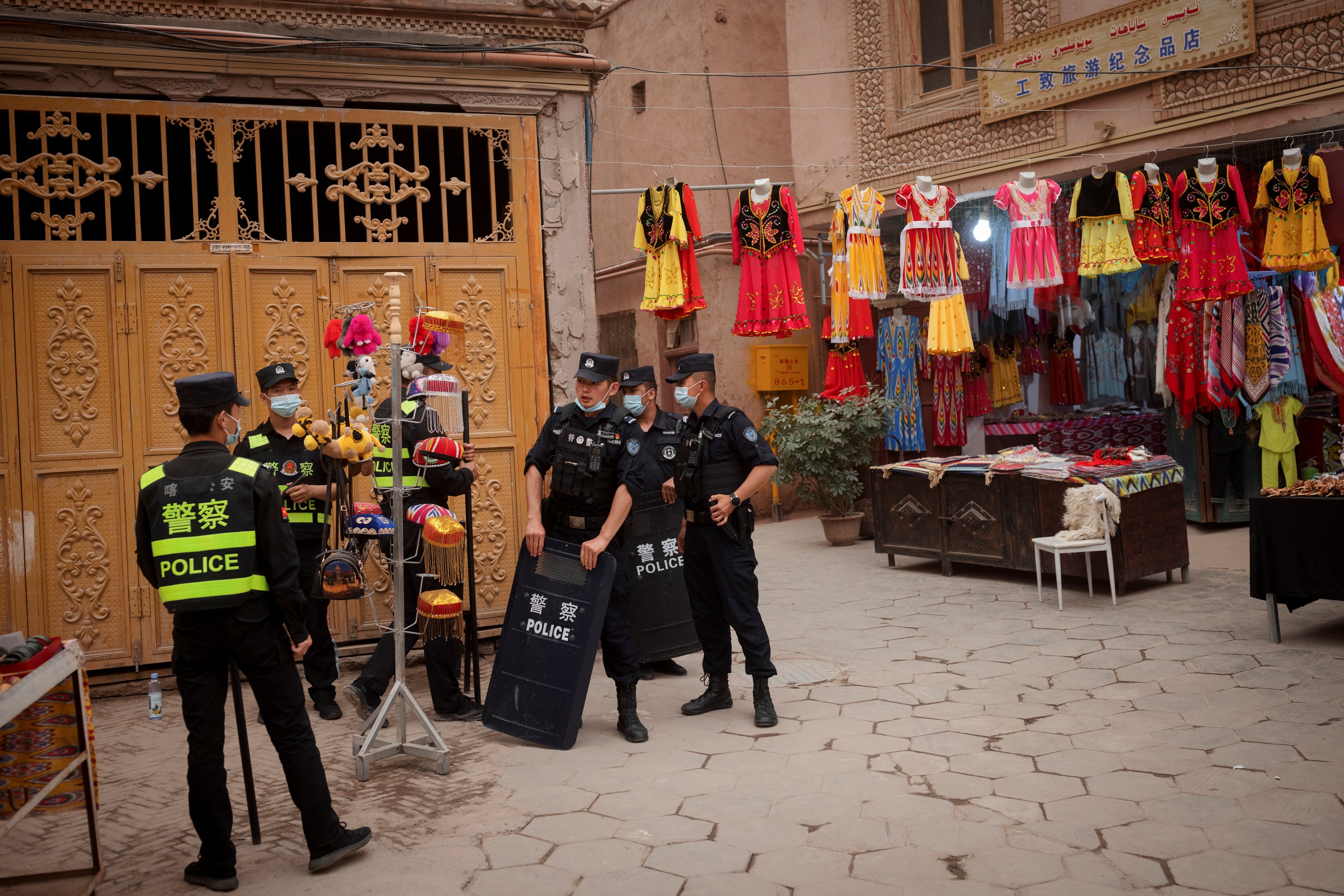 Police officers stand guard among tourist stalls in the old city in Kashgar