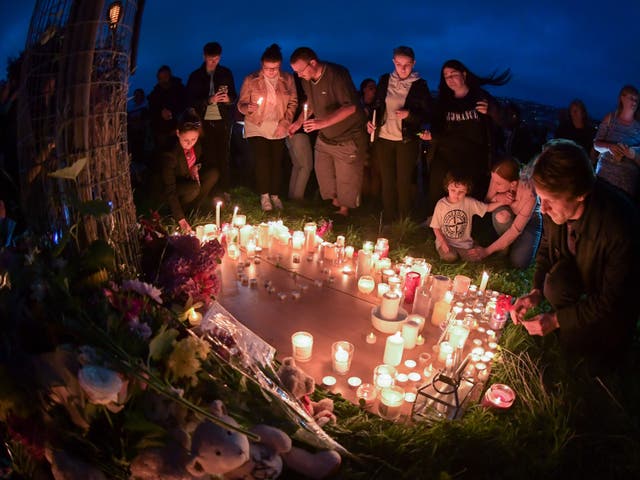 <p>People bowed their heads and held out candles in a moment on reflection in memory of the victims </p>