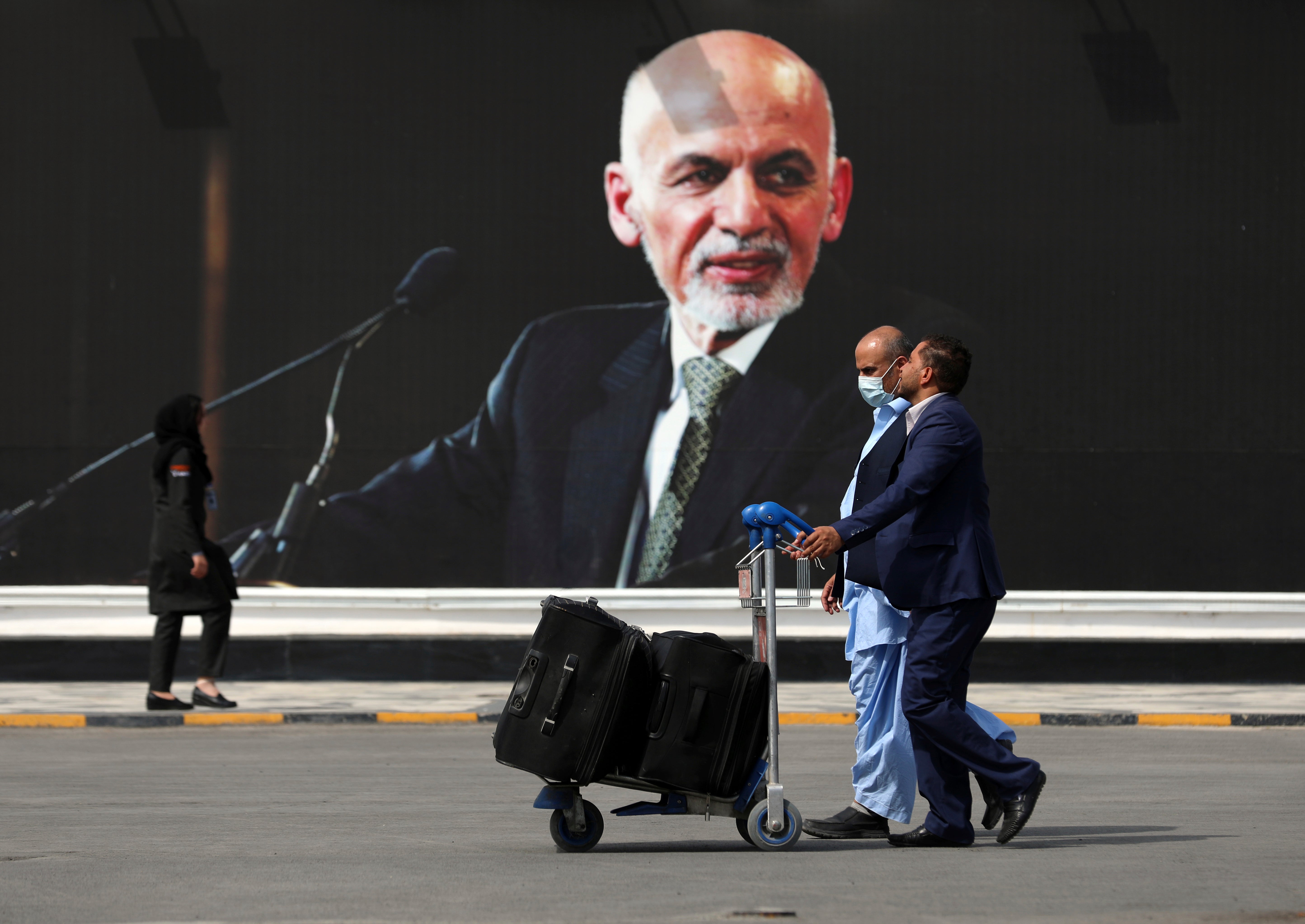 Passengers walk to the departures terminal of Hamid Karzai International Airport, in Kabul, Afghanistan, on Saturday