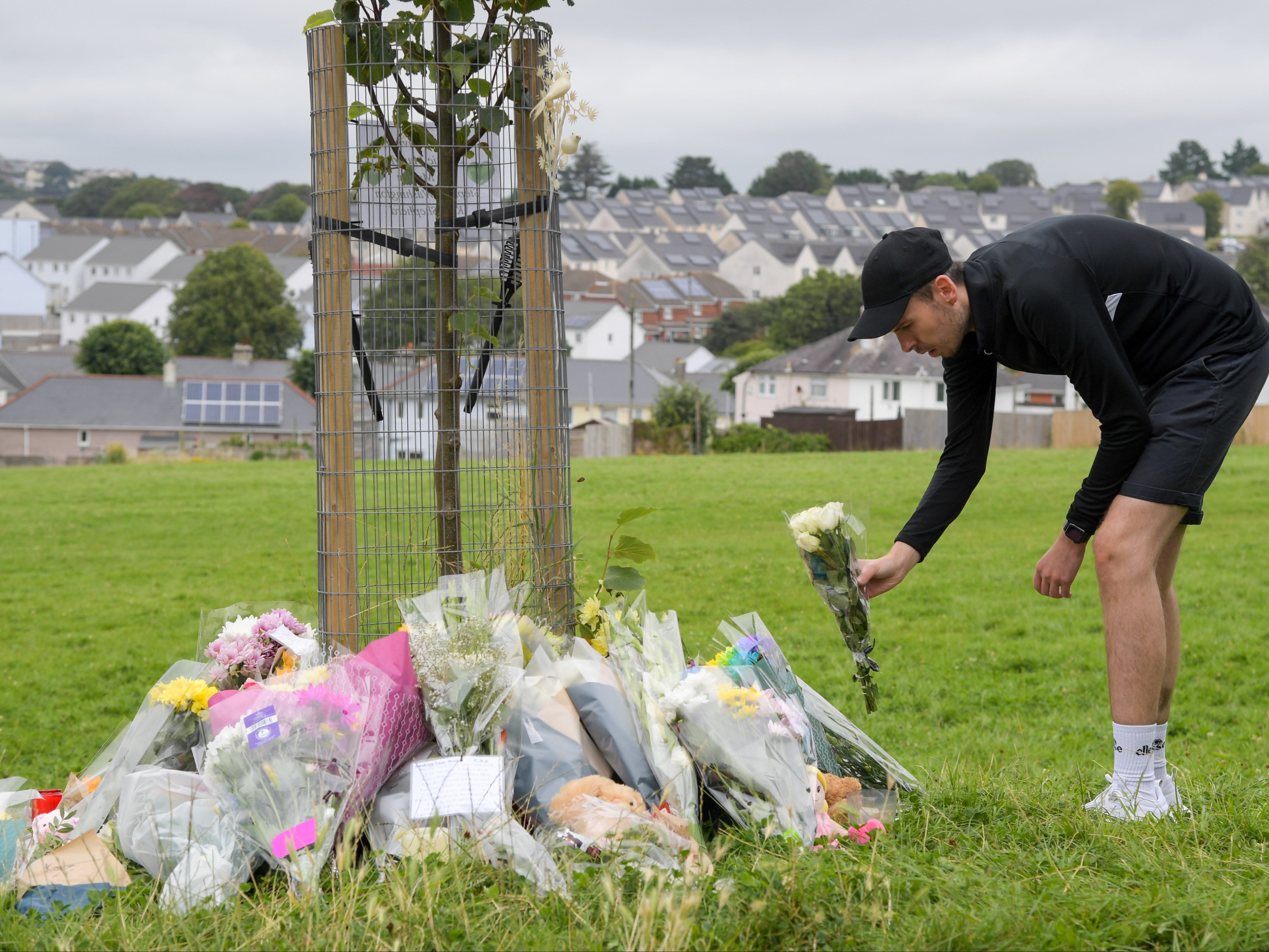 A man lays flowers at North Down Crescent Park