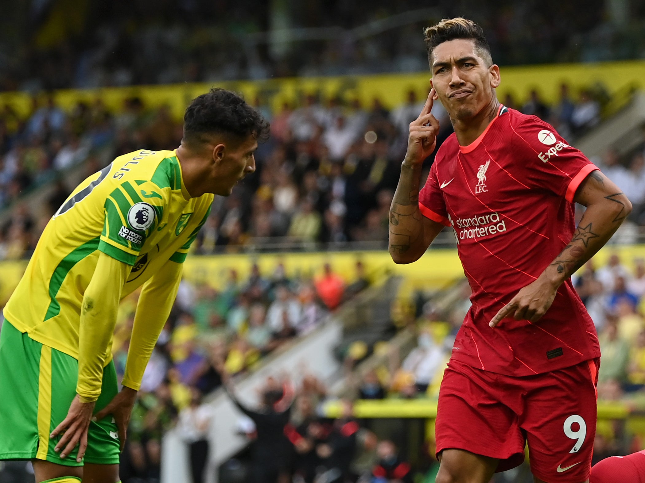 Liverpool’s Roberto Firmino wheels away after scoring his side’s second goal at Carrow Road