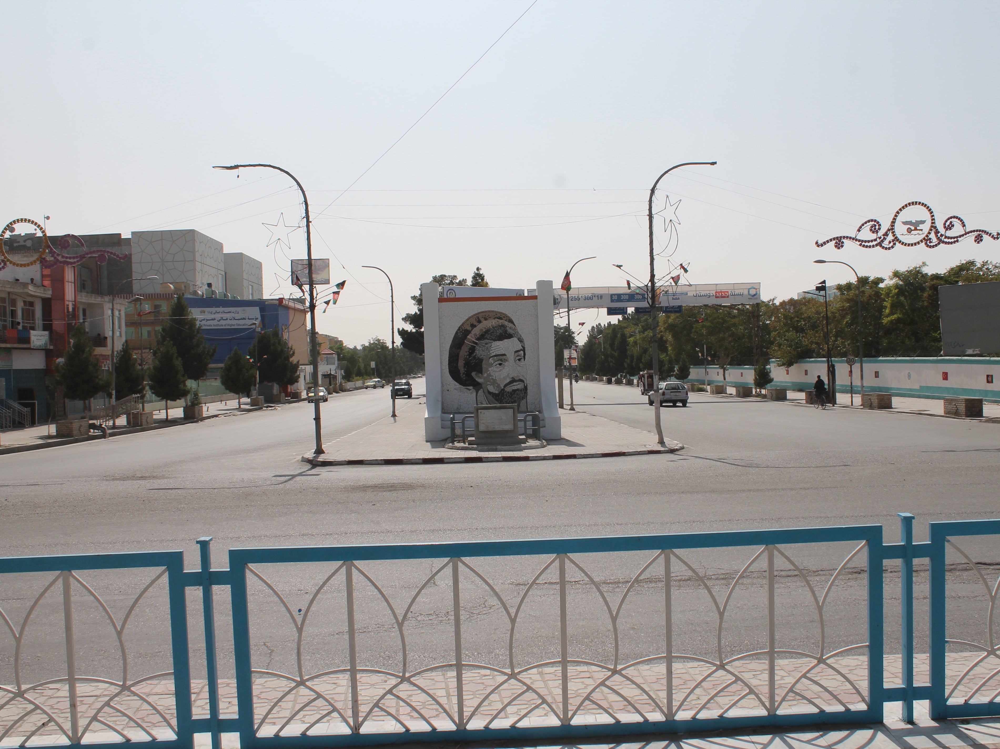 A view of a deserted road showing a monument with image of former Mujahideen commander Ahmad Shah Masood, in Mazar-e-Sharif