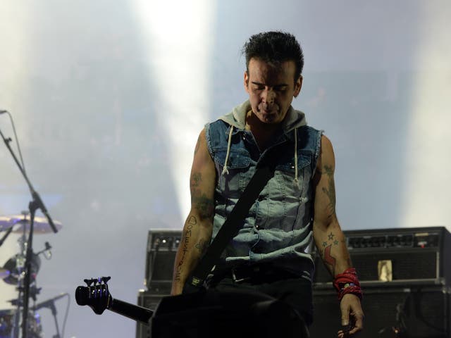 <p>Simon Gallup performing with The Cure at Lollapalooza in 2013</p>