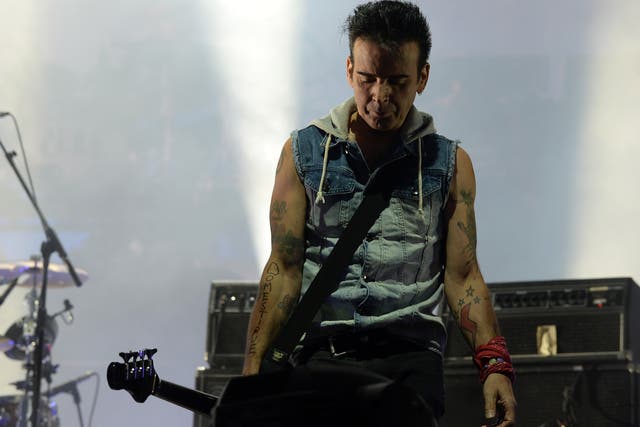 <p>Simon Gallup performing with The Cure at Lollapalooza in 2013</p>