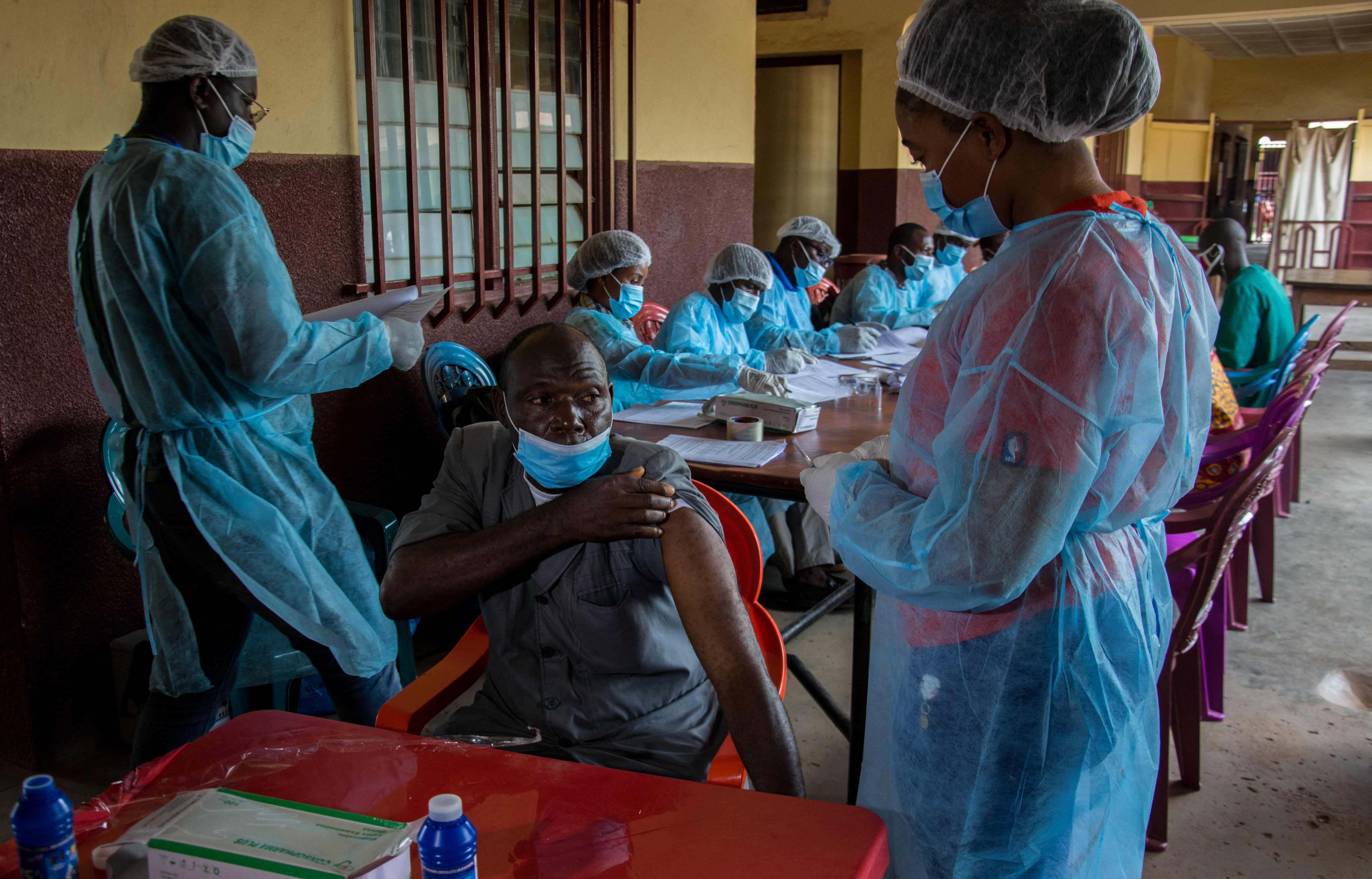 A staff member of the N’zerekore hospital lifts his shirt sleeve as he prepares to get his anti-ebola vaccination in Guinea earlier this year