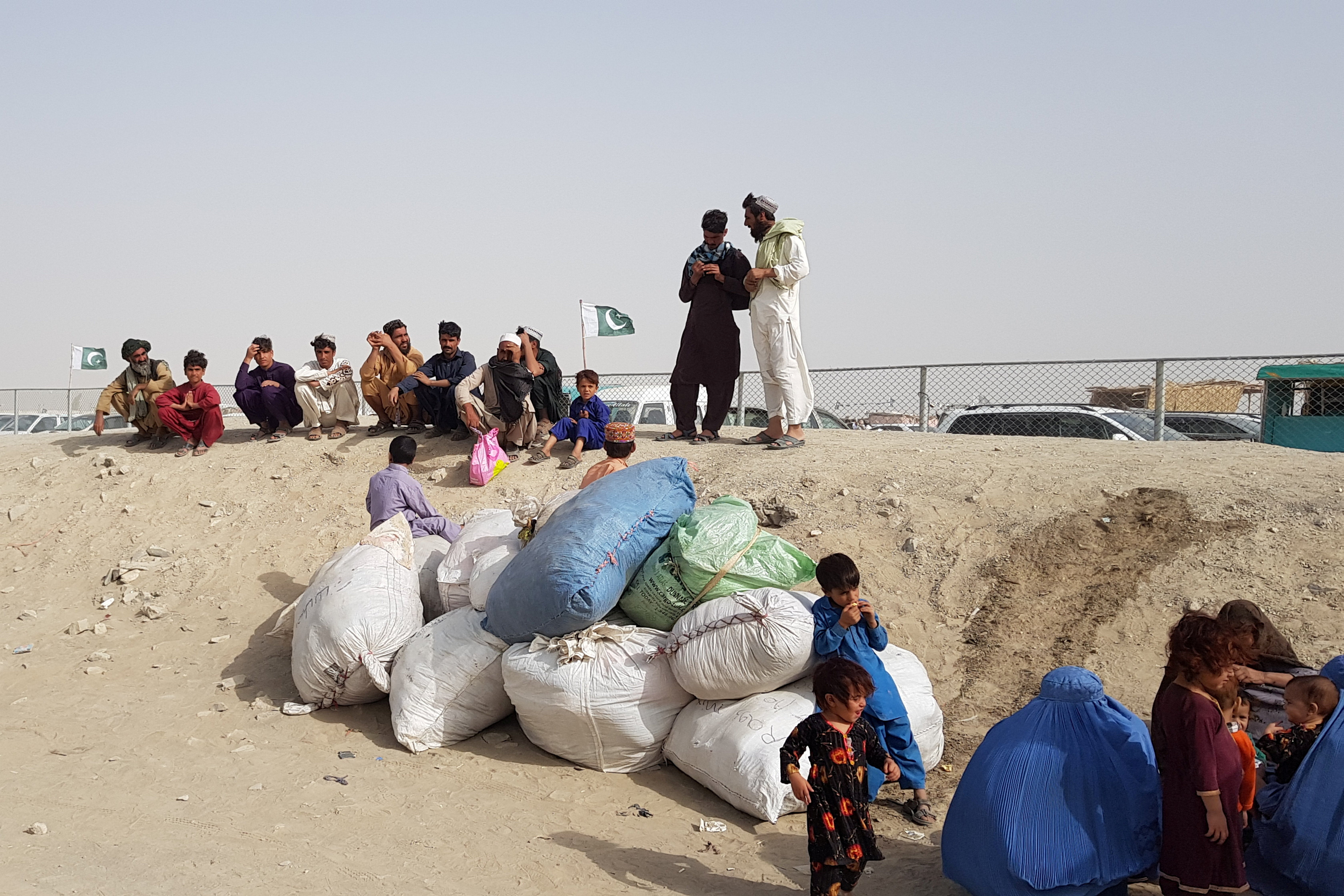 A family with their belongings wait to cross the Friendship Gate crossing point at the Pakistan-Afghanistan border town of Chaman