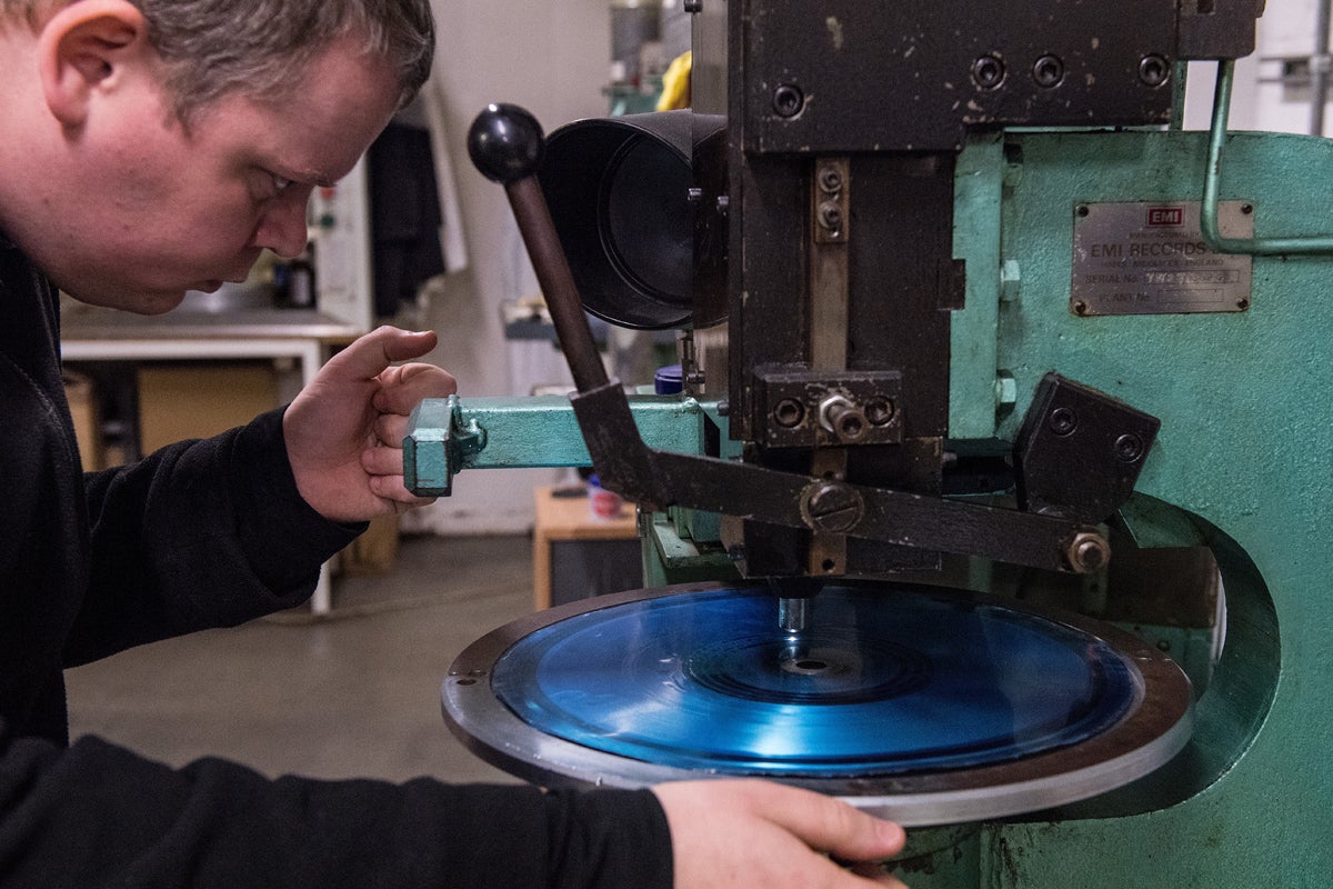 Vinyl Factory worker Martin Frings checks a finished master is usable. He looks at the grooves through a microscope