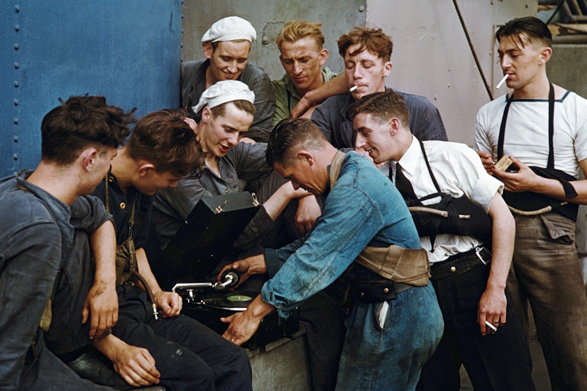 The crew of a royal navy ship listen to a gramophone while on patrol in the Atlantic, circa 1943