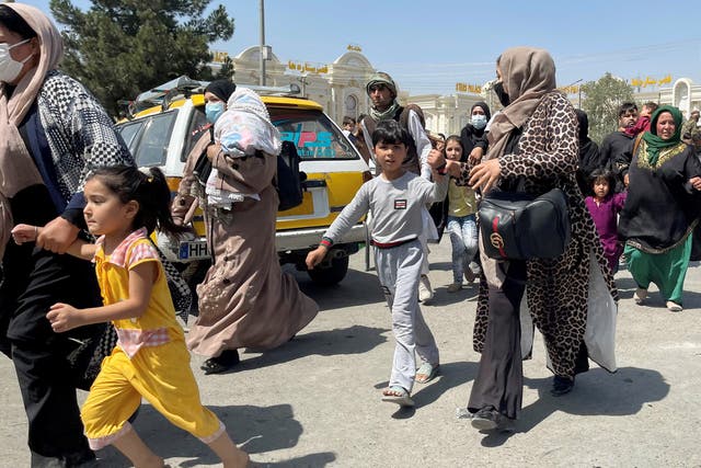 Las mujeres afganas se apresuran al aeropuerto internacional Hamid Karzai con sus hijos el 16 de agosto de 2021.