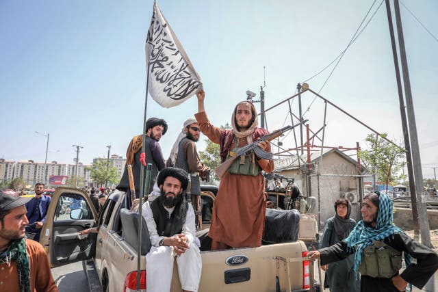 <p>Taliban fighters are seen on the back of a vehicle in Kabul, Afghanistan</p>