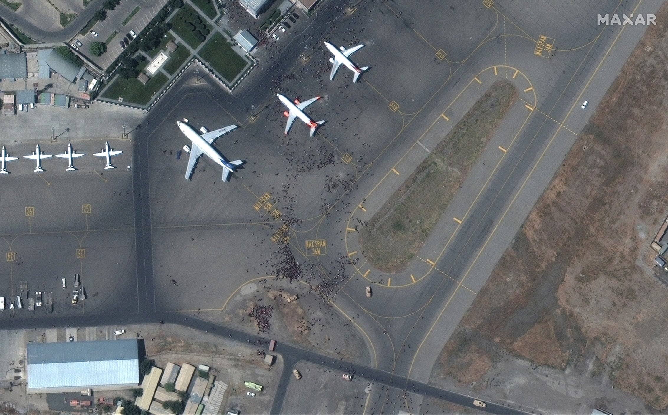 Satellite images show crowds of people swarming planes at the Kabul airport on Monday, 16 August, 2021.