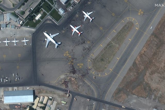 <p>Satellite images show crowds of people swarming planes at the Kabul airport on Monday, 16 August, 2021.</p>